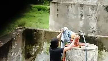 Indian village girl bathing near water tank outdoor